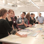 group of people looking at projects in classroom