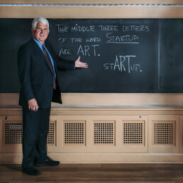 Bob Metcalfe standing in front of chalk board