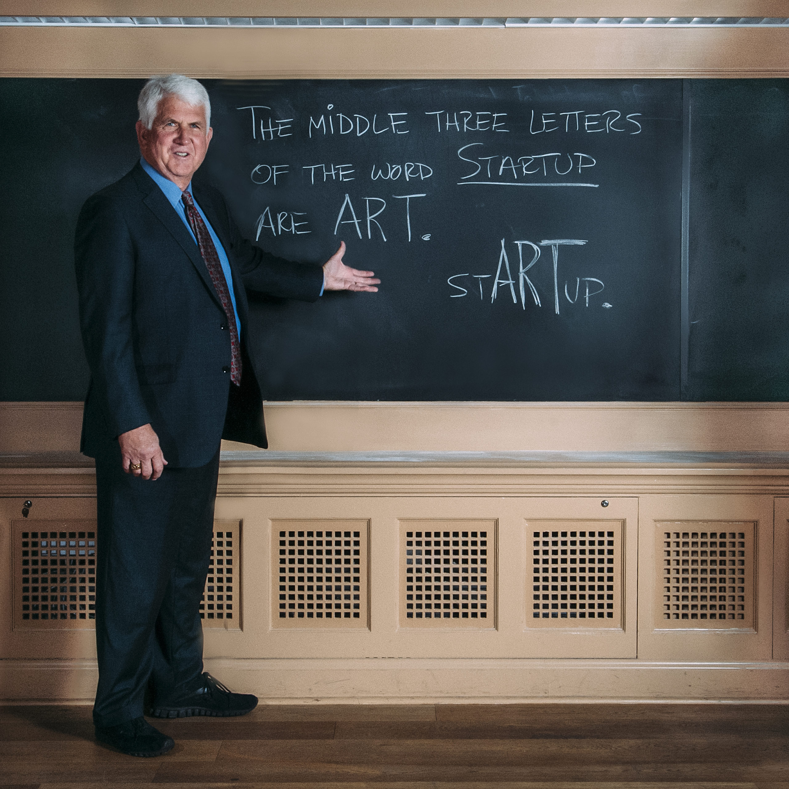 Bob Metcalfe standing in front of chalk board