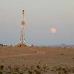 landscape view with oil rig and rising moon