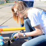 student working on small airplane