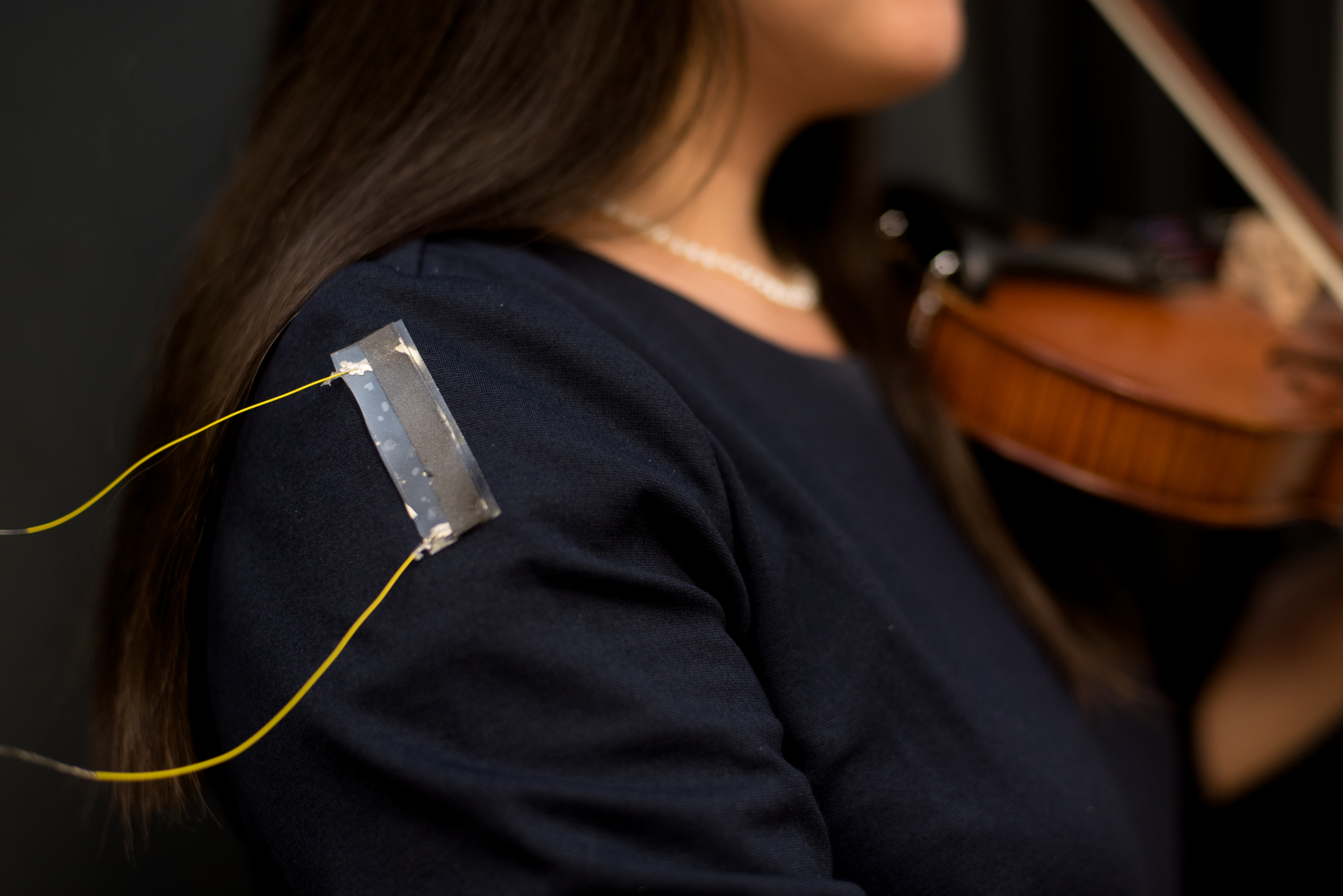 Thin adhesive film and two wires attached to a shoulder to display the flexible strain sensor