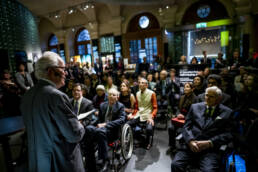 2019 nobel laureates listening to a speaker at the nobel museum