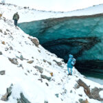 Two people scaling a glacier in Antarctica