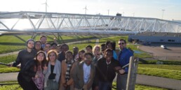 students standing in front of wind turbines in amsterdam