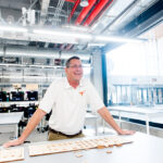 Texas Engineering staff Steve Ferraro leaning on table in Texas Inventionworks maker space