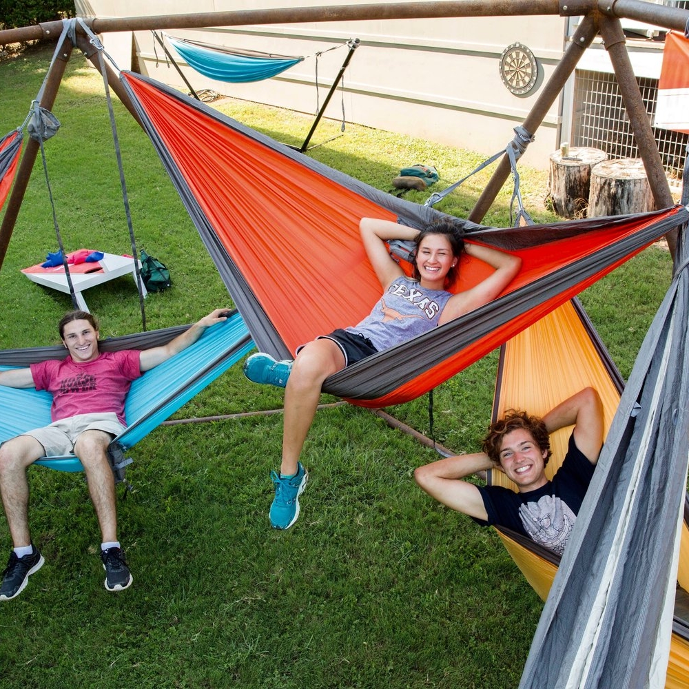 students lounge in hammocks in large hammock structure