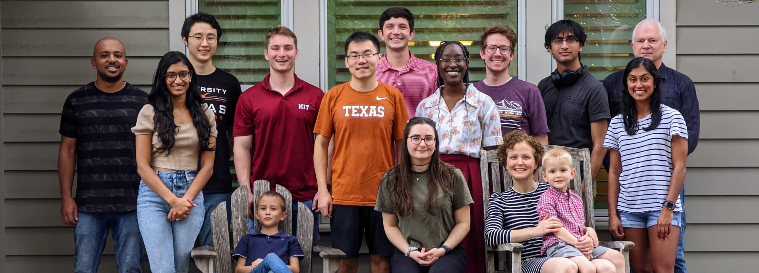 Texas Engineering students and faculty smiling on front porch with children
