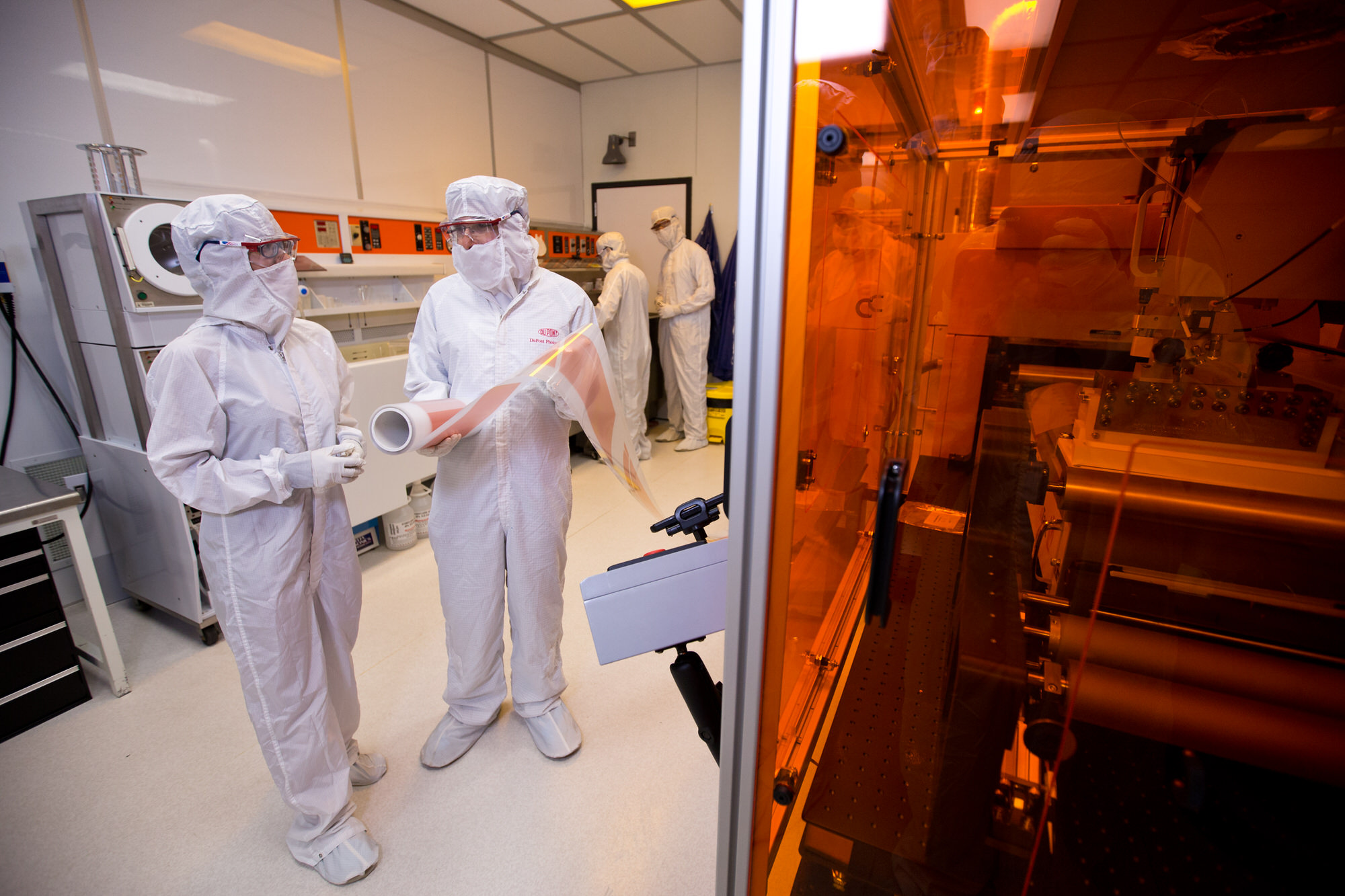Texas Engineers dressed in lab gear in a semiconductor lab
