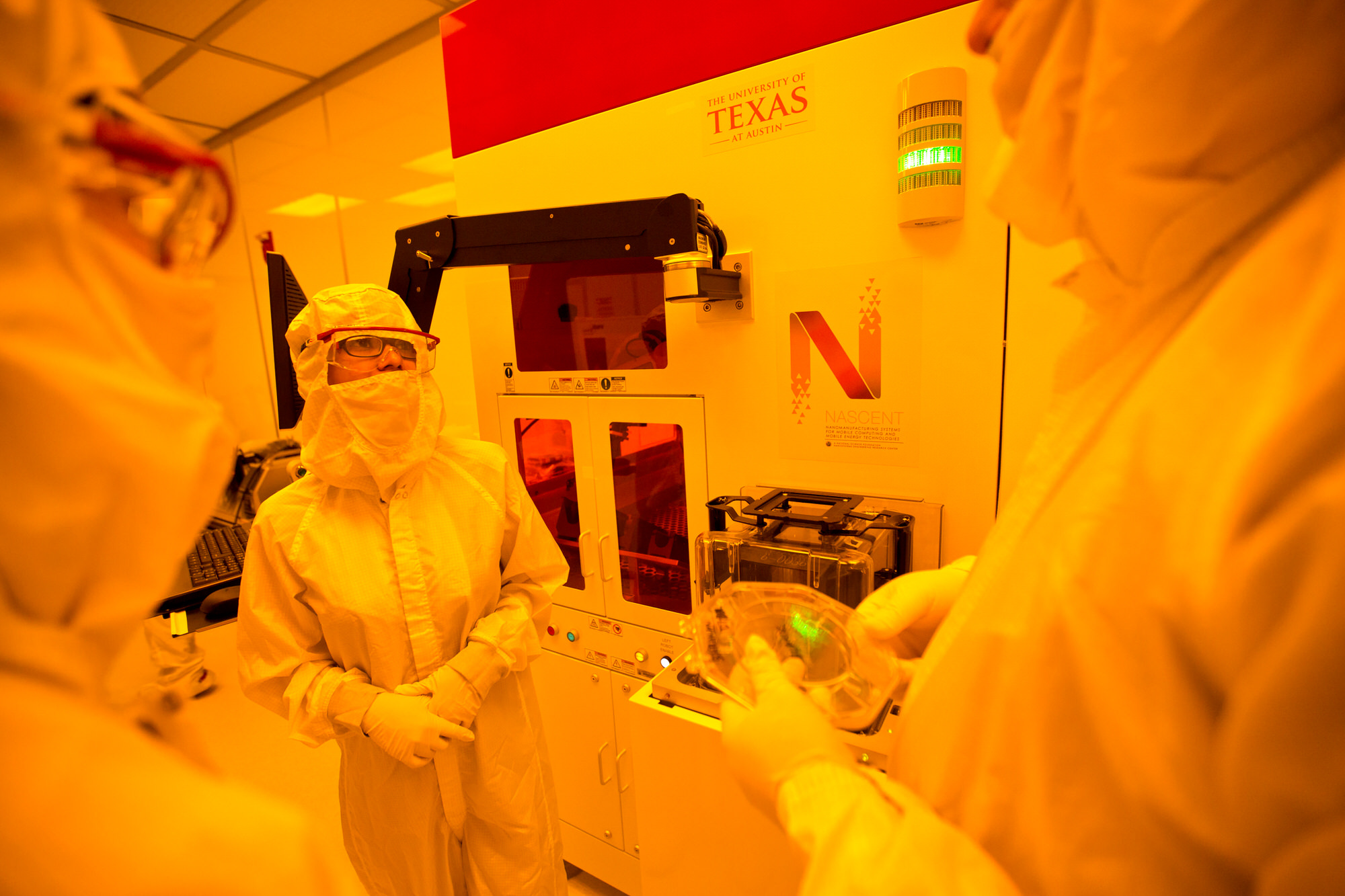 Texas Engineers dressed in lab gear standing in front of NASCENT machine