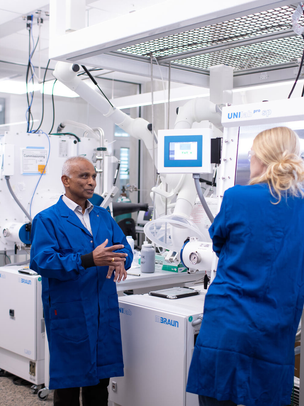 Texas Engineer Arumagam Manthiram talk to staff in his battery research lab