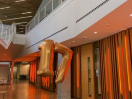 A seventeen balloon floating in an engineering hallway