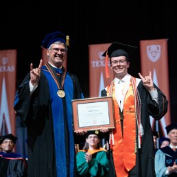 Dean Roger Bonnecaze and Matthew Nattier at on commencement stage holding a diploma