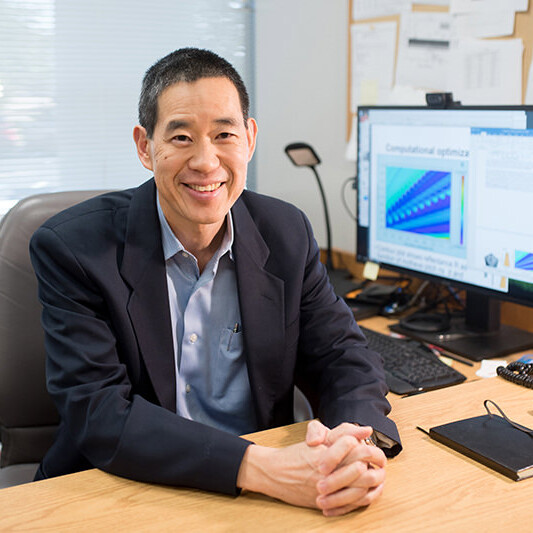 Texas Engineer Edward Yu sitting at a desk and smiling