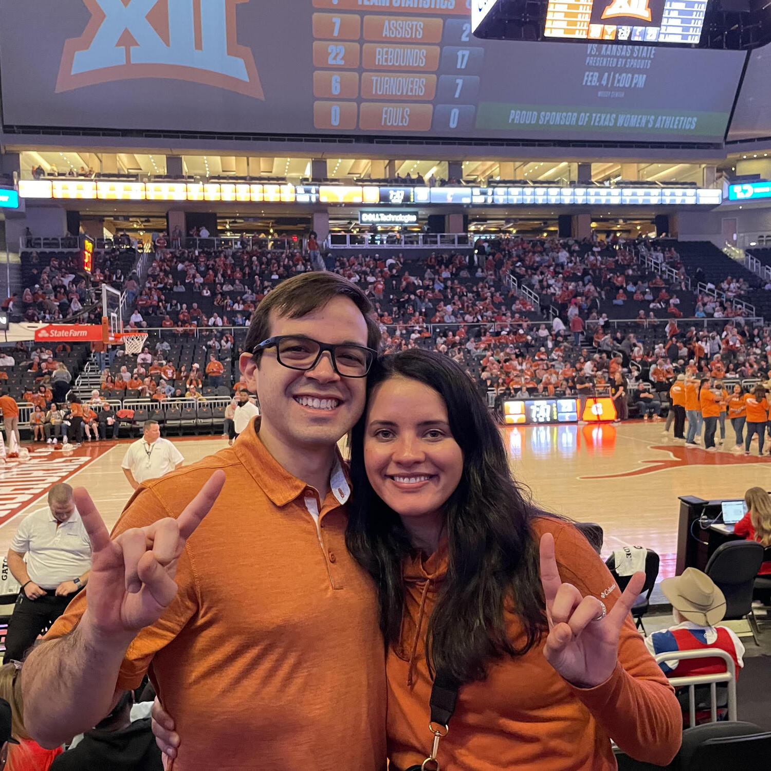 Texas Engineers Laura Rivera and Santiago Echeverri doing hook 'em horns hand signat basketball game
