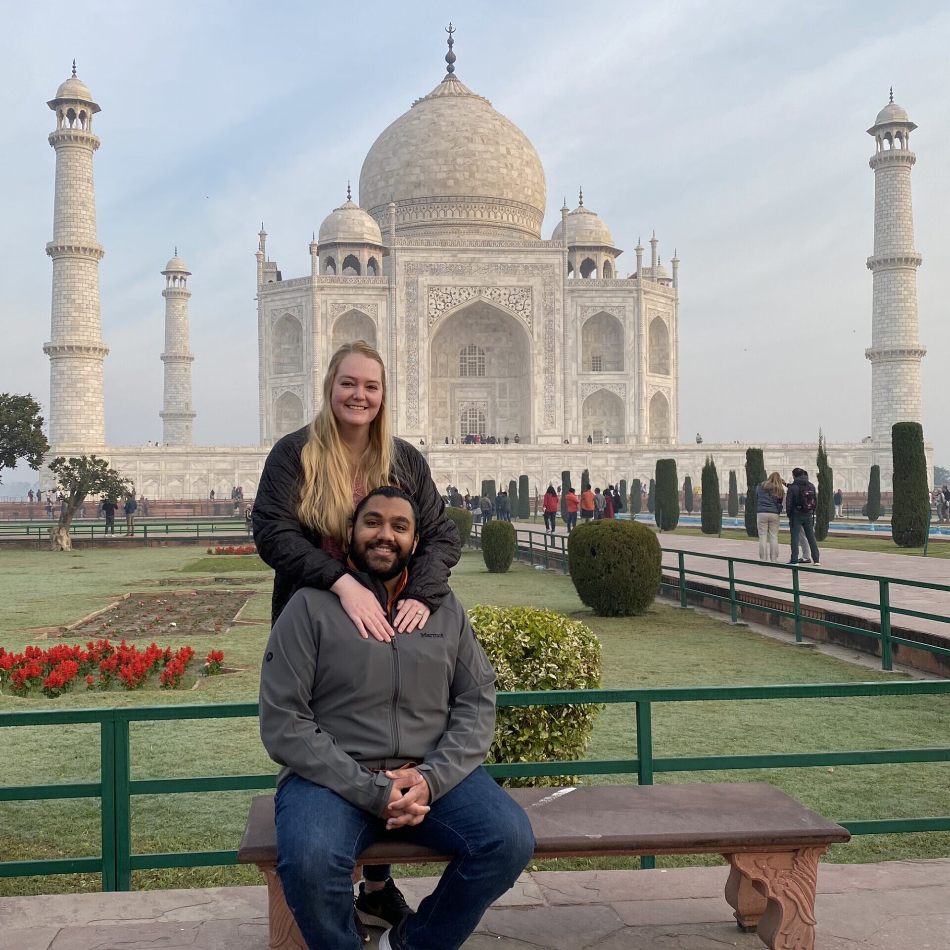Texas Engineers Kelsea and Amritpreet Kang sitting on a bench in front of ornate building