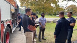 Texas Engineers talking to firefighters in front of fire truck