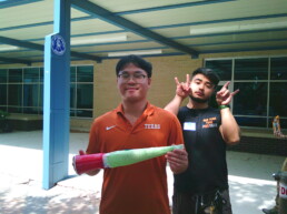 Longhorn Engineering Summer Camp counselors holding rocket prototype