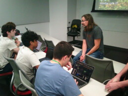 Texas Engineer Michael Pyrcz sitting on table while teaching LESC counselors