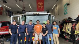 Texas Engineers, including Siddharth Thakur, standing with firefighters in front of fire truck