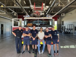 Texas Engineer Siddharth Thakur sitting with firefighters in front of fire truck