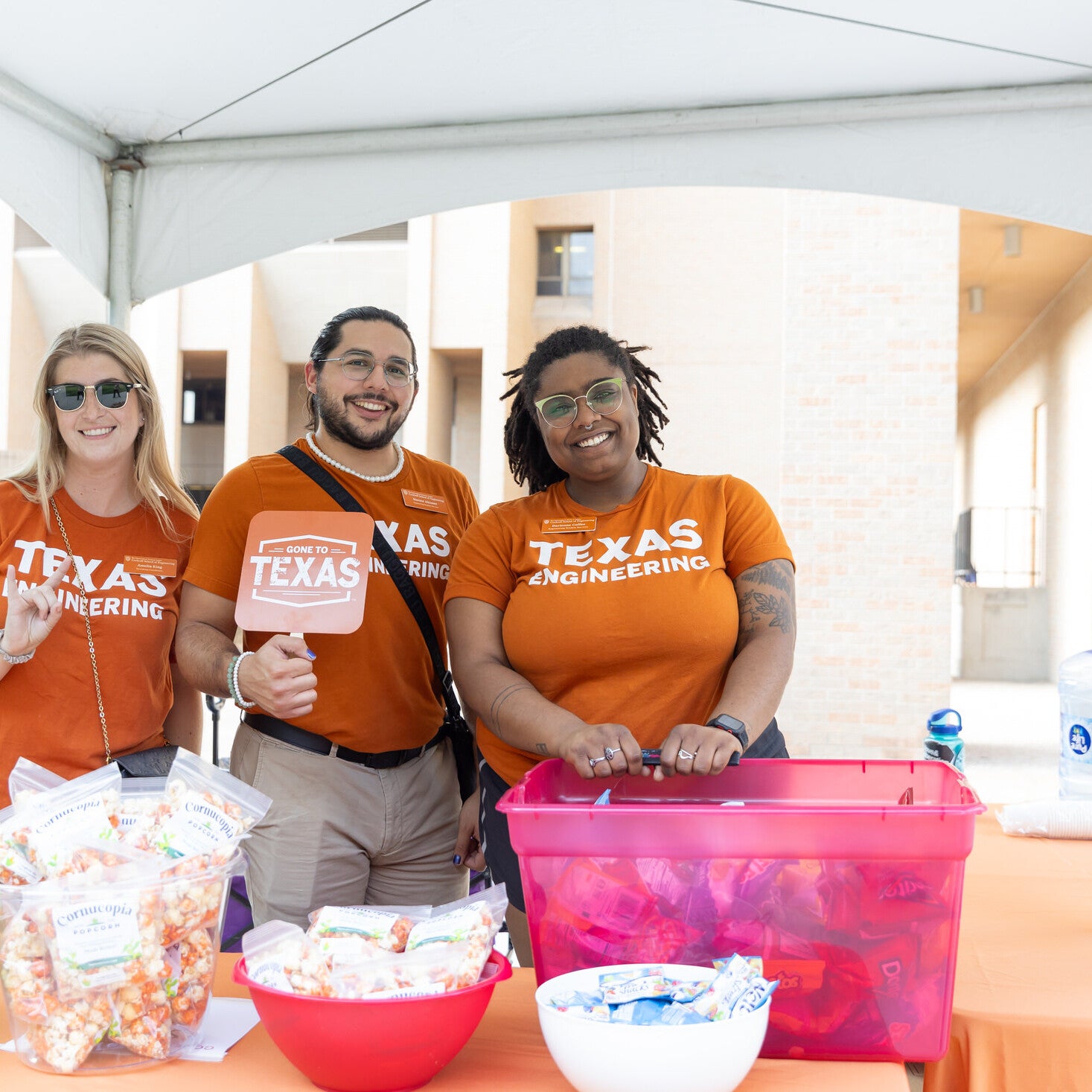ESS advisors smiling in front of table with grab bags at event