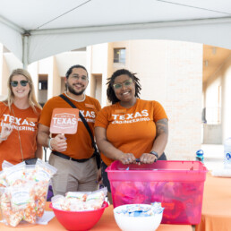 ESS advisors smiling in front of table with grab bags at event