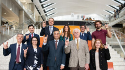 UT Portugal team poses with hook em on the steps of the EER building on Forty Acres.
