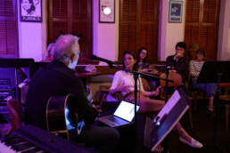 Darden Smith interviewing Clara Saracho while holding guitar to help gather content for live songwriting