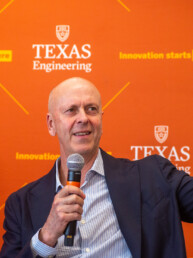 Texas Engineer David Baldwin waving while holding microphone at UT event