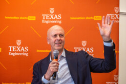 Texas Engineer David Baldwin waving while holding microphone at UT event