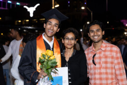 Texas Engineer Siddharth Thakur wearing cap and gown smiling at graduation with his family