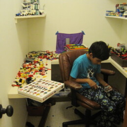 Young Siddharth Thakur surrounded by legos in childhood home.