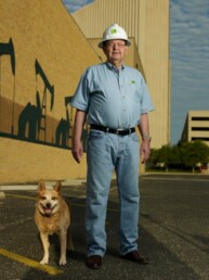 Texas Engineer Autry C. Stephens wearing hardhat standing near construction site with his dog