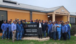 Shay Ralls Roalson (center) smiling in front of Austin Water building with Austin Water staff.