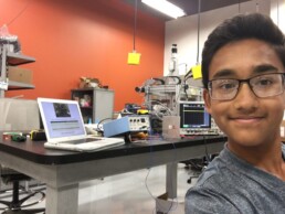 Childhood Siddharth Thakur taking selfie in laboratory with first Firebot prototype.