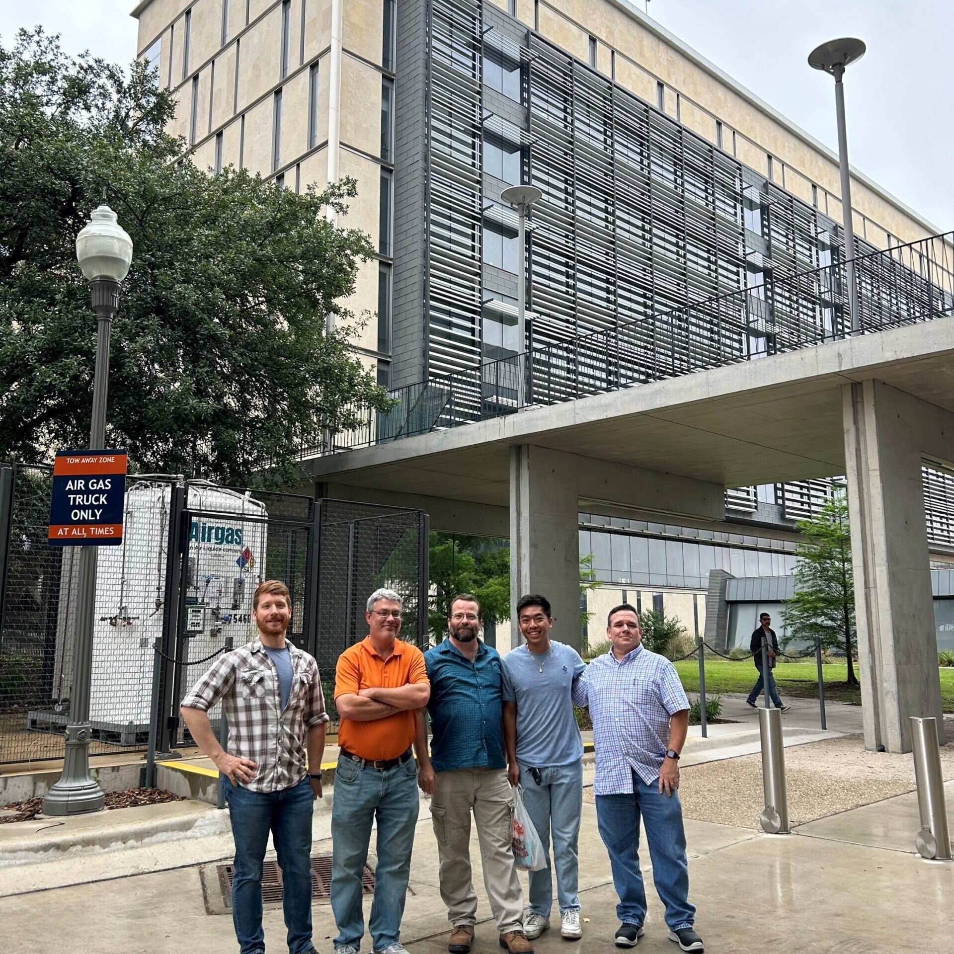 Cockrell building management all-start team stands in front of EER building.