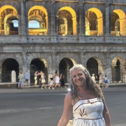 Kiersten Fernandez in front of historic building in Greece.