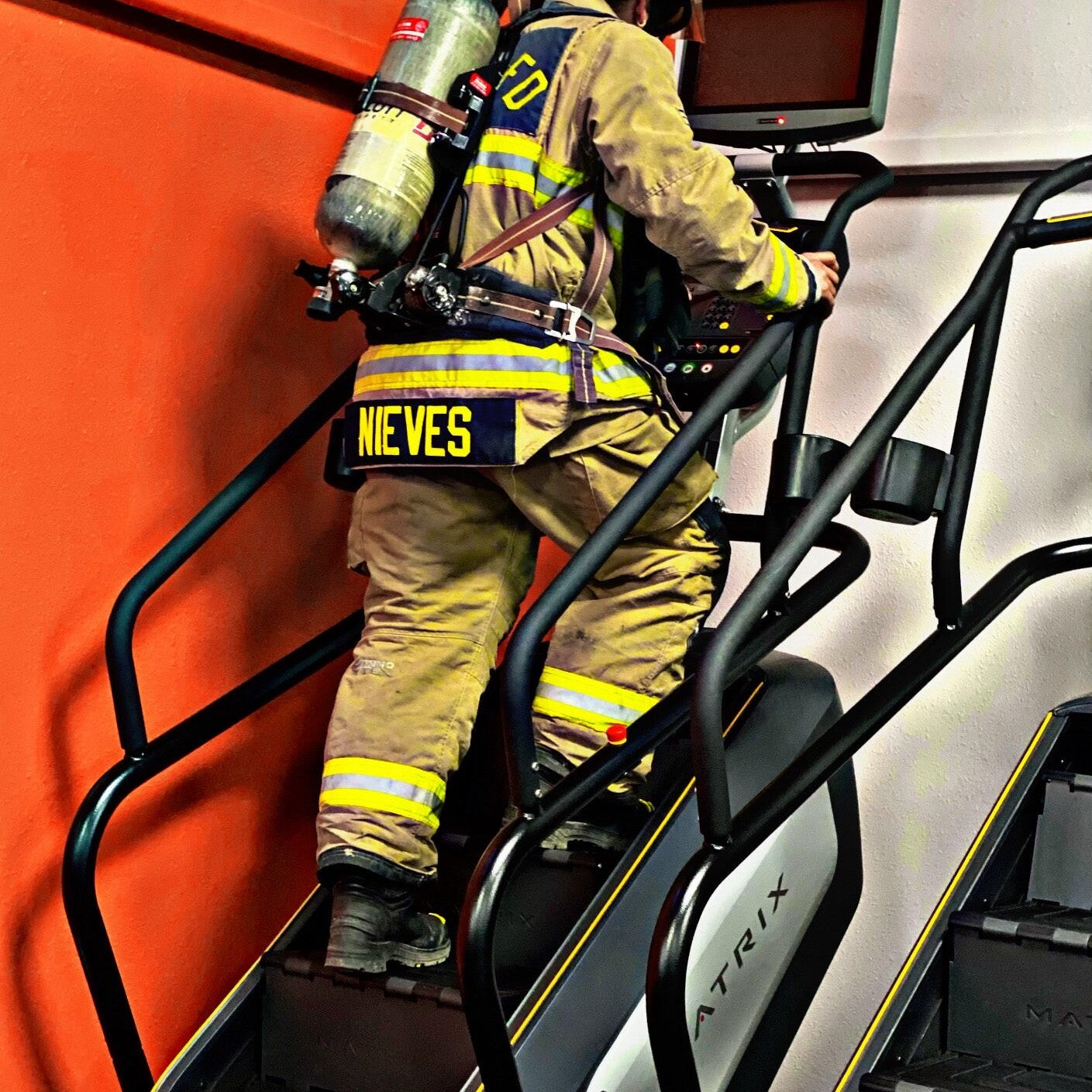 Guillermo Nieves dressed in firefighting gear walking on a stepmaster