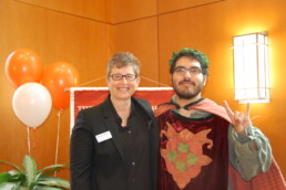 Michele Myer smiling with student in Alec costume at orientation event.