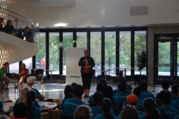 Michele Myer presenting at orientation event in EER in front of large group of students